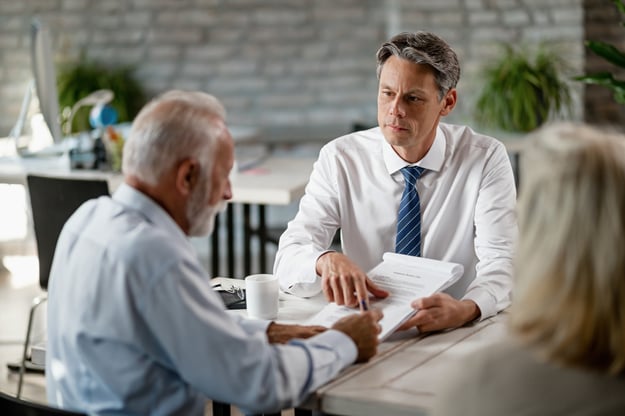 insurance-agent-having-meeting-with-senior-clients-pointing-place-signature-contract